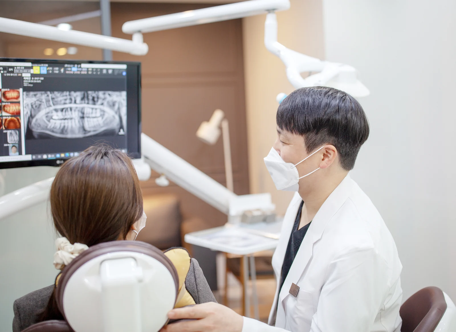 디지털 심미보철 상담, 원장이 환자와 파노라마 사진을 보며 상담하는 모습